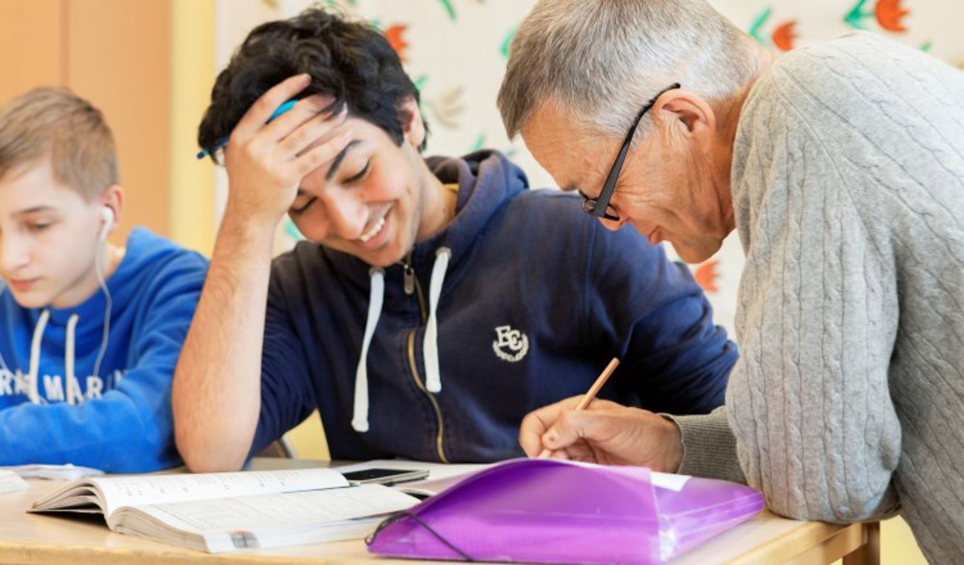 Foto: NTB scanpix Credit: Oslo kommune Eldre lærer hjelper ung gutt.