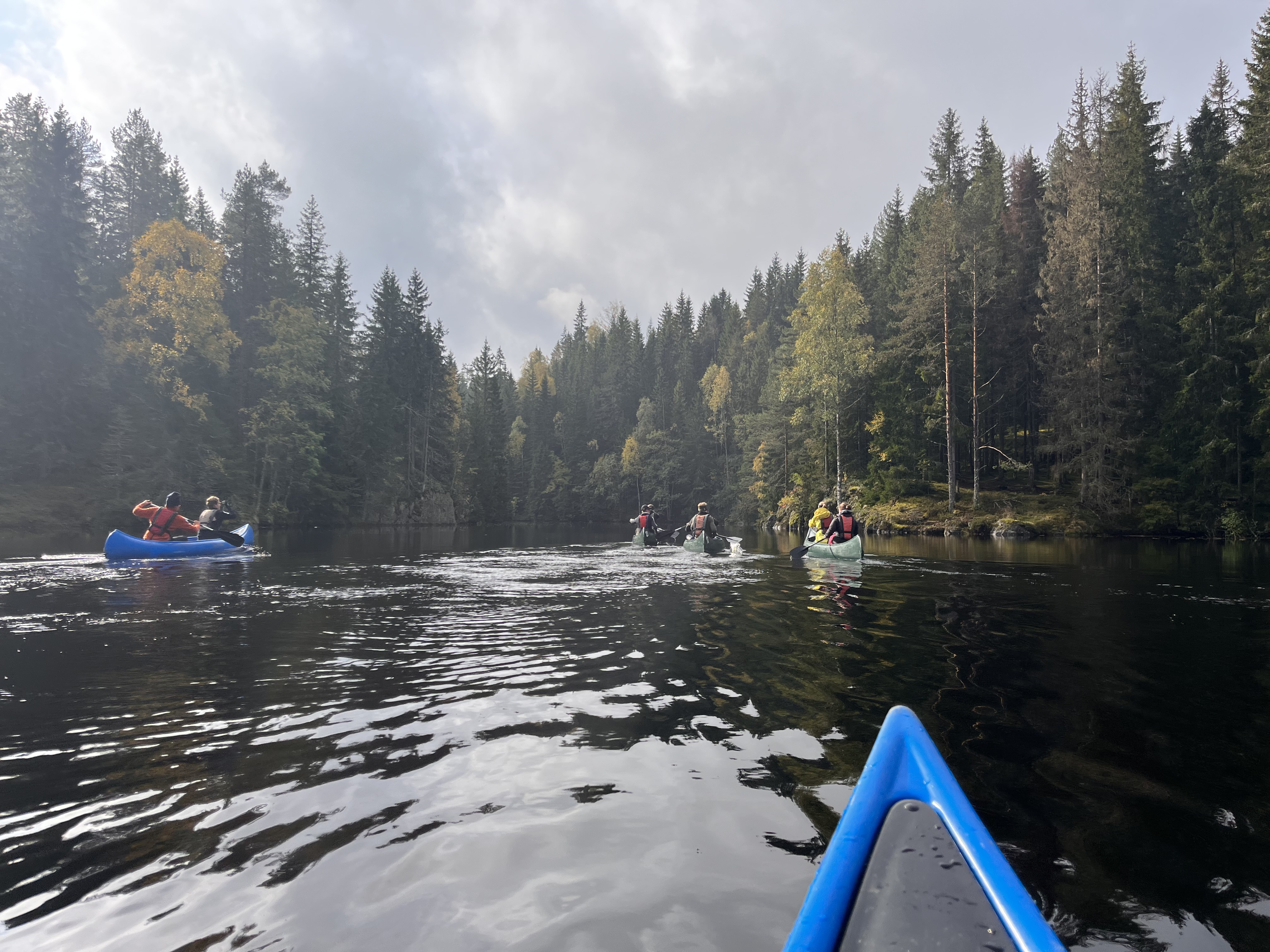 En gruppe mennesker i båter på en elv